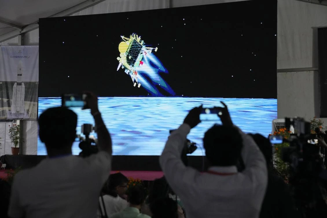 Journalists film the live telecast of spacecraft Chandrayaan-3 landing on the moon at ISRO's Telemetry, Tracking and Command Network facility in Bengaluru, India. (AP)