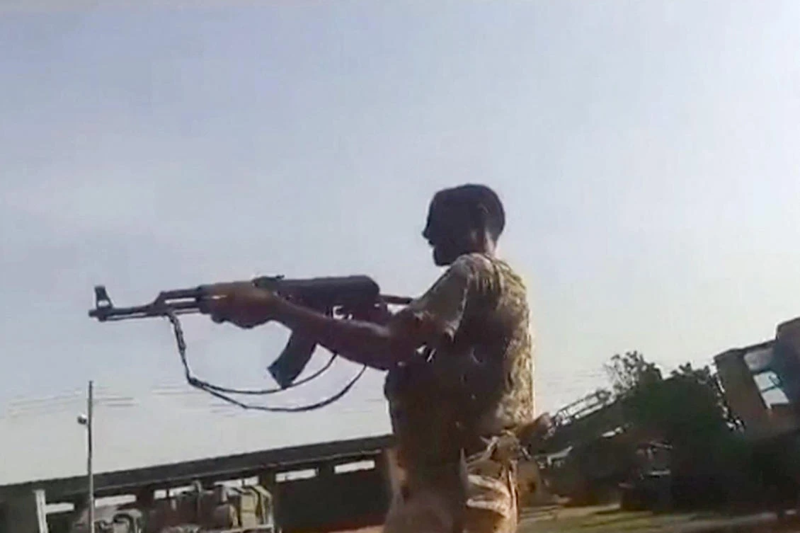 A grab from a UGC video shows members of the Sudanese army firing at RSF fighters in what they say is the Al-Shajara military base in Khartoum. (AFP)