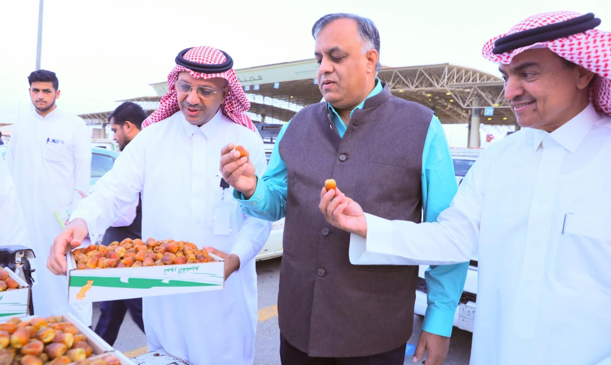 Indian envoy Suhel Ajaz Khan tries dates at the Buraidah festival. (Supplied)