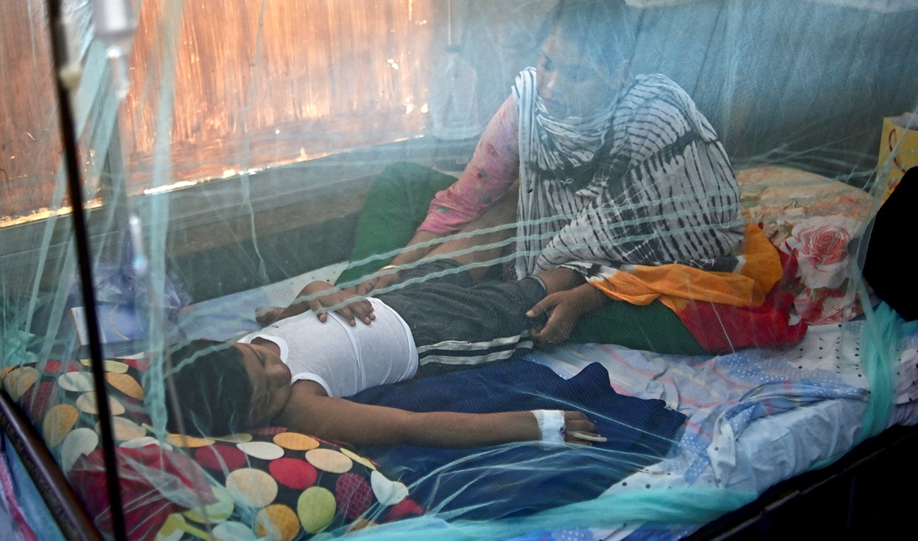 A woman comforts a child suffering from dengue fever at a government hospital in Dhaka on Oct. 19, 2022. (AFP/File)