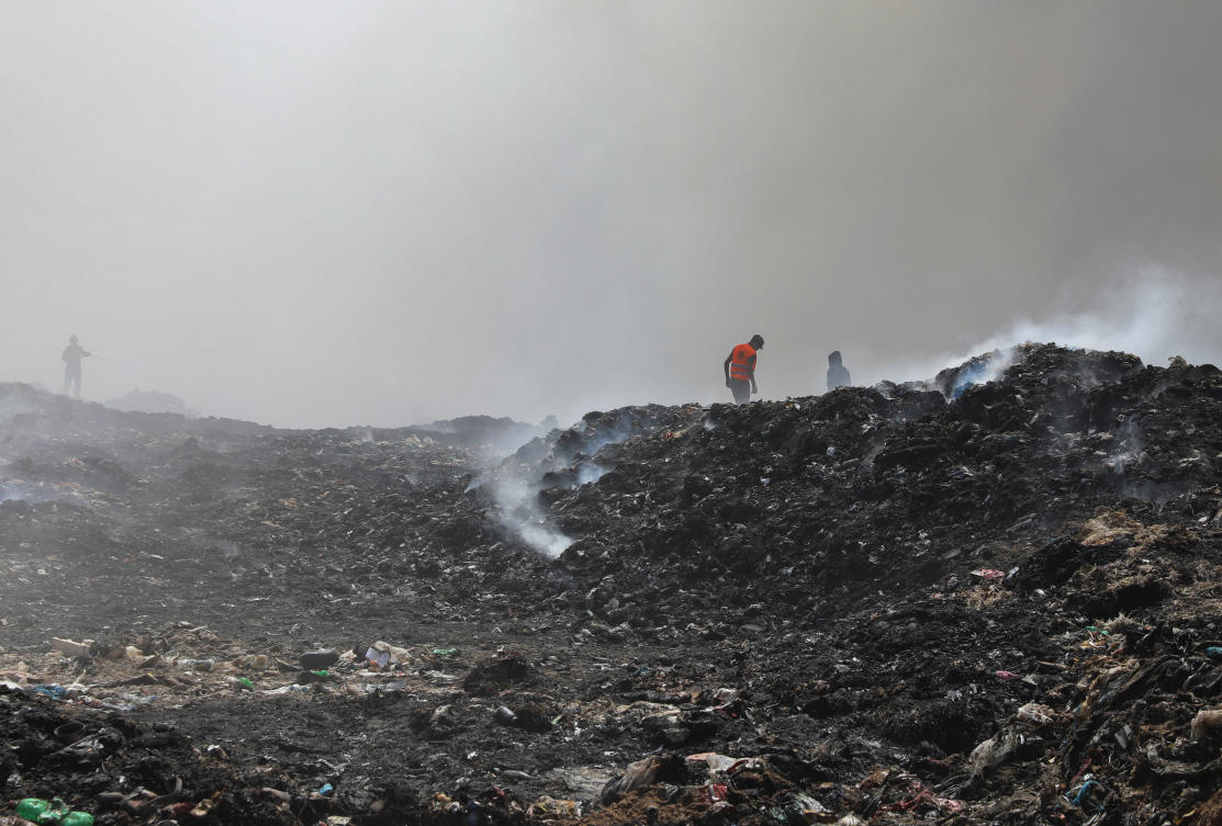 Palestinian firemen extinguish a fire at a landfill in Juhr al-Deek, southeast of Gaza City, September 3, 2023. (Reuters)
