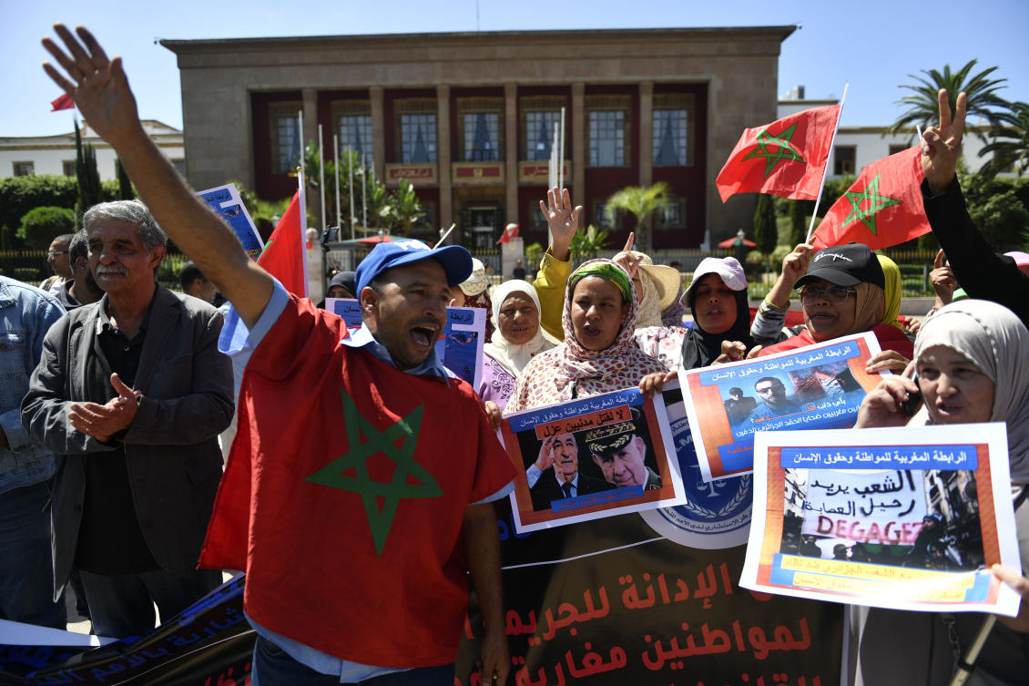 People hold banners and gather to stage a protest in Rabat to condemn the killing of two men by Algerian forces after they strayed across Morocco's maritime border with Algeria on water scooters. (AP)