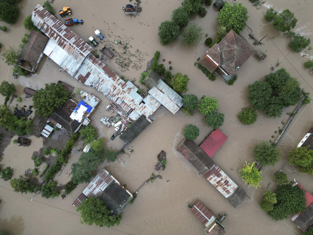 Floodwaters cover a farm and a house after the country's record rainstorm (AP)
