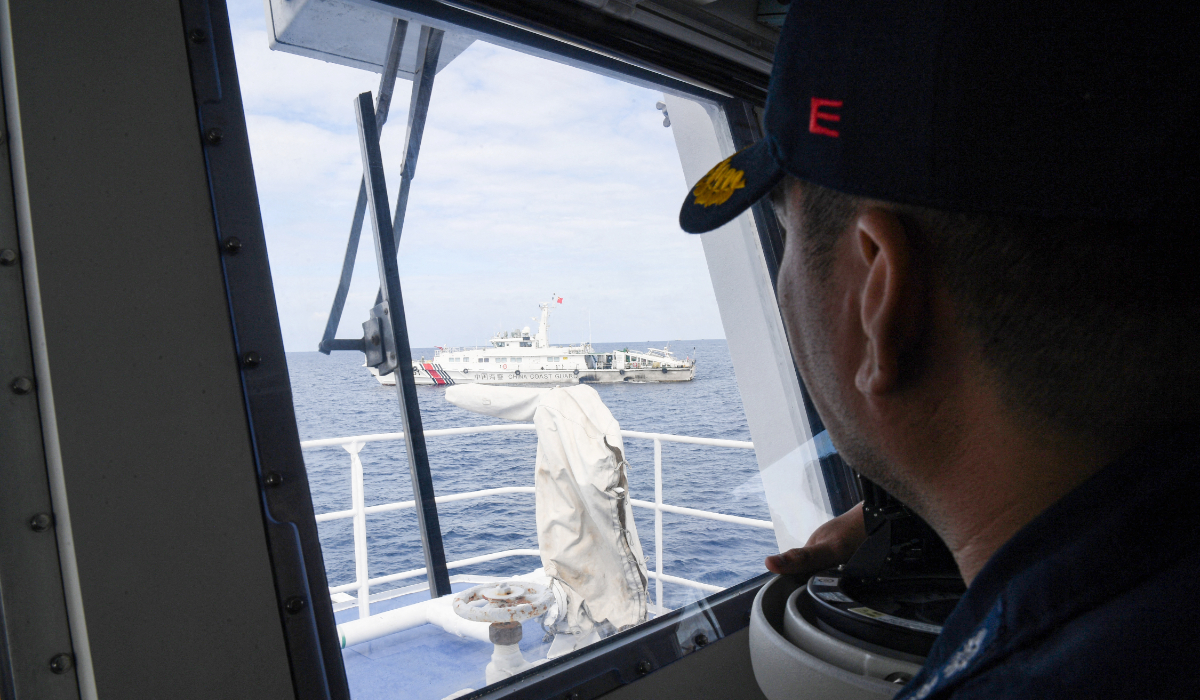 This photo taken on August 22, 2023 shows the skipper of Philippine coast guard BRP Cabra Emmanuel Dangate observing a Chinese coast guard ship during the re-supply mission by a civilian boat chartered by the Philippine navy to deliver supplies to Philippine navy ship BRP Sierra Madre in the disputed South China Sea. (AFP)