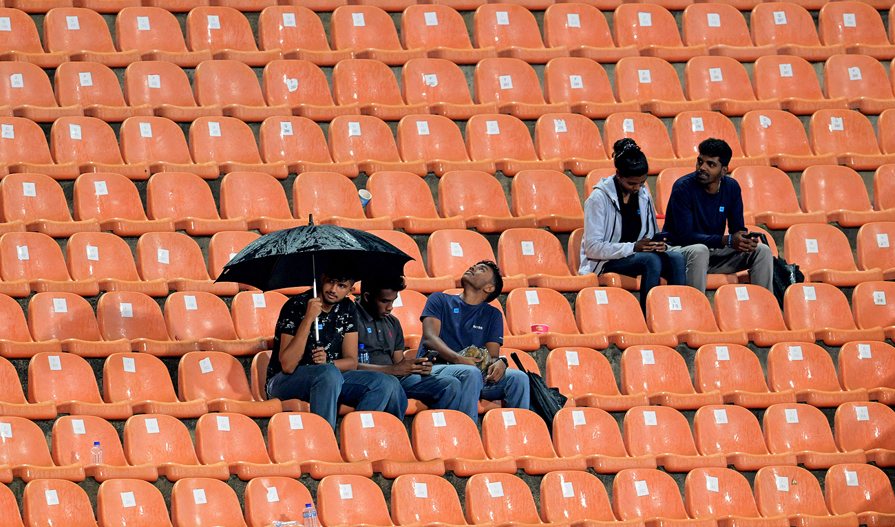 Fans wait out a rain delay during the Asia Cup 2023 one-day international (ODI) cricket match between India and Pakistan at the Pallekele International Cricket Stadium in Kandy on September 2, 2023. (AFP)