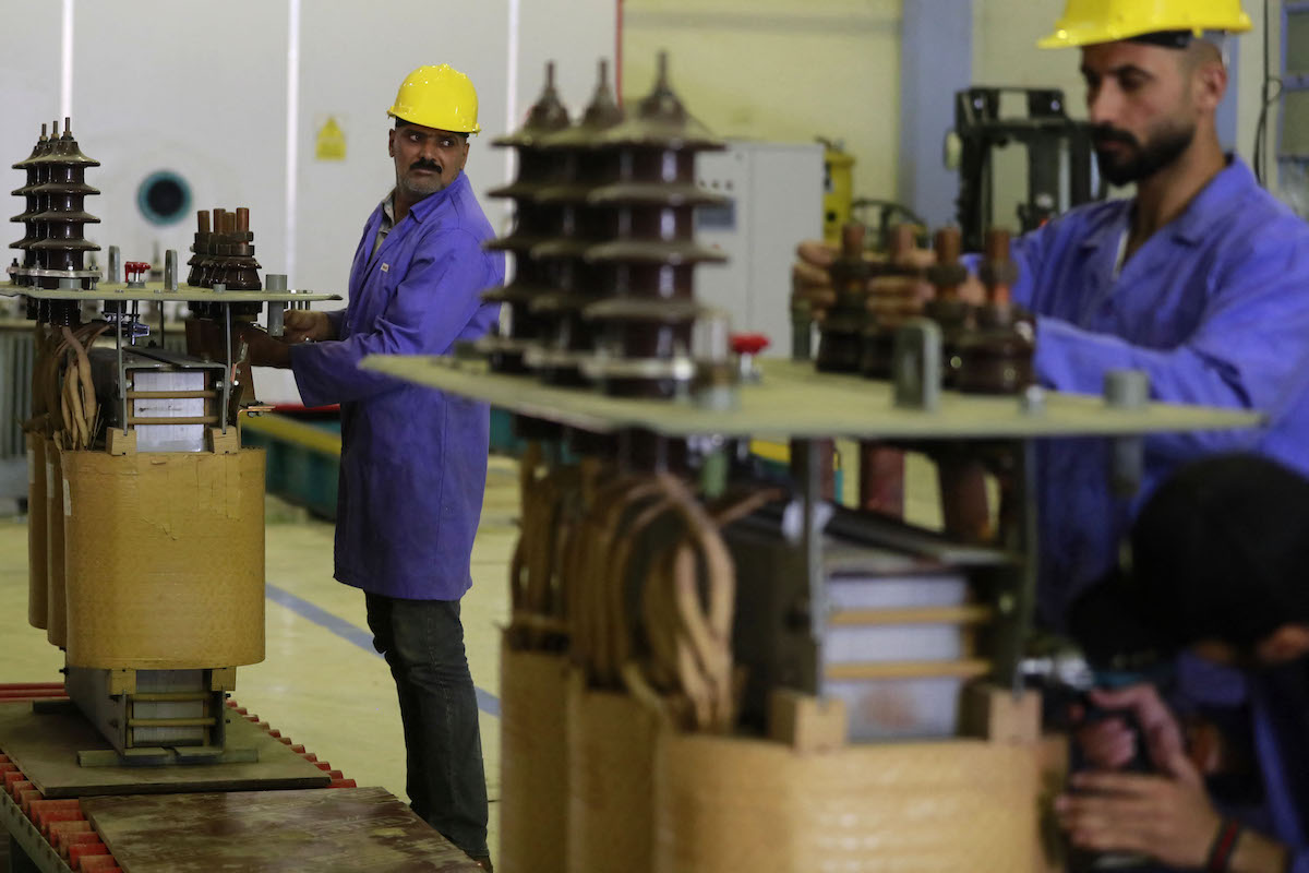 Iraqi men work in the manufacture of electrical transformers in a factory in Baghdad. (File/AFP)