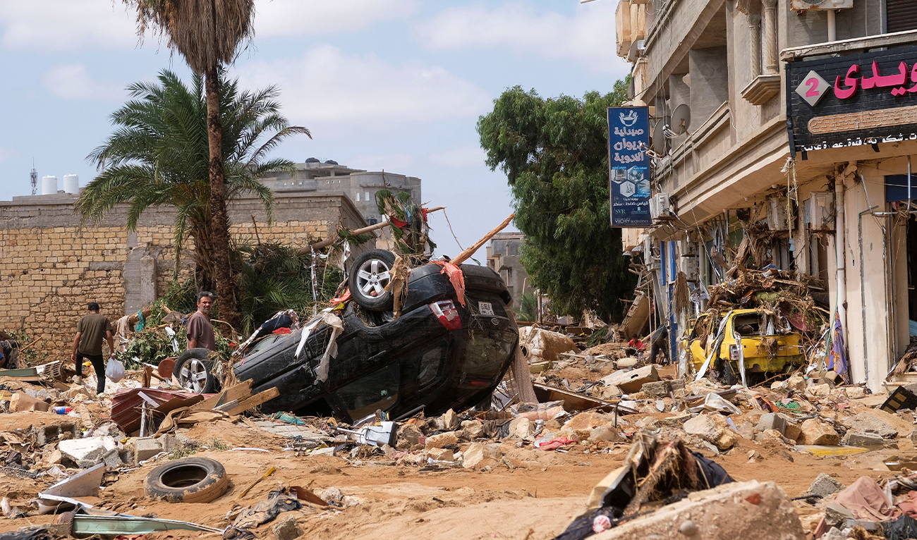 A man stands next to a damaged car, after a powerful storm and heavy rainfall hit Libya, in Derna, Libya on September 12, 2023. (Photo courtesy: REUTERS/TPX IMAGES)