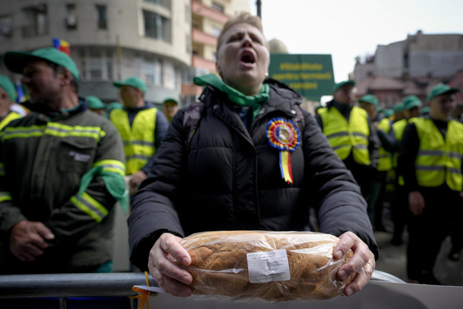 A woman holds a loaf of bread during a farmers' protest in front of the Representative Office of the European Commission in Bucharest on, April 7, 2023 (File/AP)