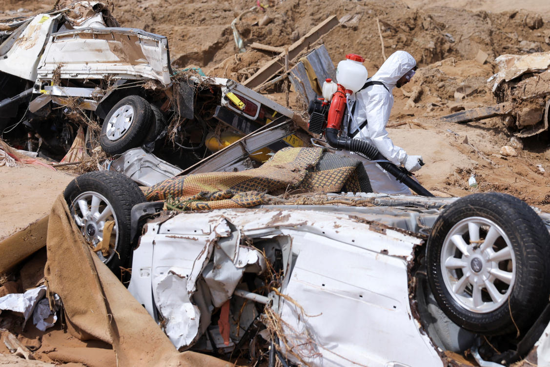 A sanitation worker disinfects rubble, amid rising concerns of spread of infectious diseases, as dead bodies started to decompose following floods in Derna, Libya on Sept. 17, 2023. (Reuters)
