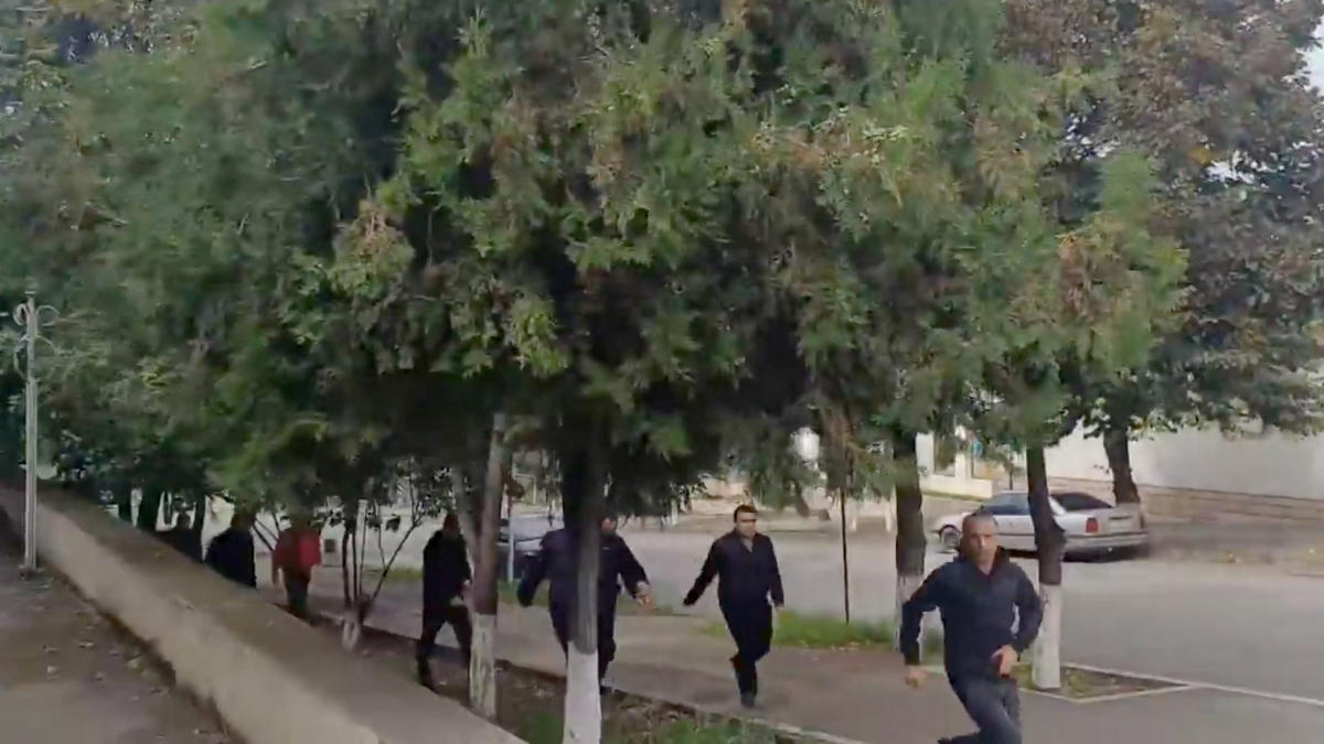 People run as gunfire and explosions are heard in Stepanakert, called Khankendi by Azerbaijan, in the Nagorno-Karabakh region, on Sept. 19, 2023, in this screengrab obtained from a handout video. (Reuters)
