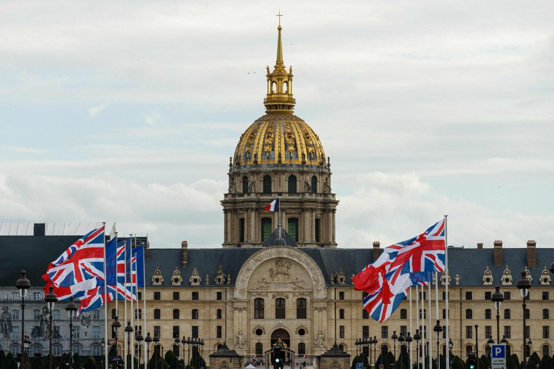 French and British national flags in front of the Hotel des Invalides in central Paris, as part of preparations for the upcoming visit of Britain's King Charles III and Queen Camilla in France. (AFP)