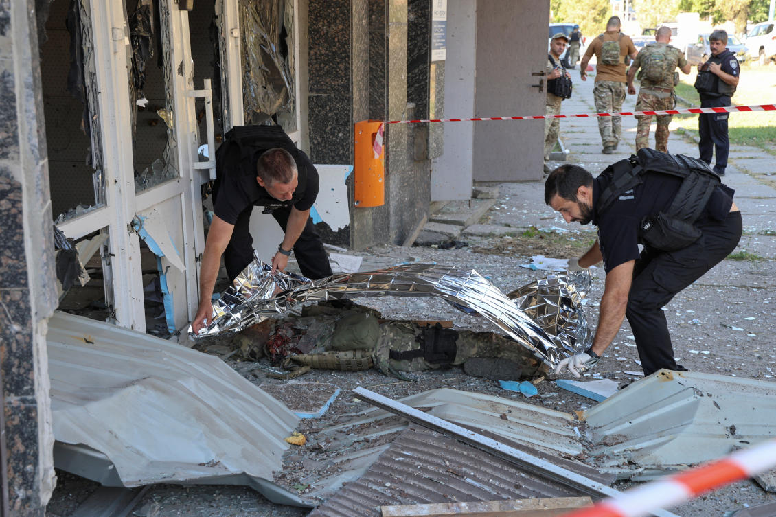 Police officers cover the body of their mate Andrii Tarchynskyi, who was killed during a Russian military strike, amid Russia’s attack on Ukraine, in Kherson. (REUTERS)