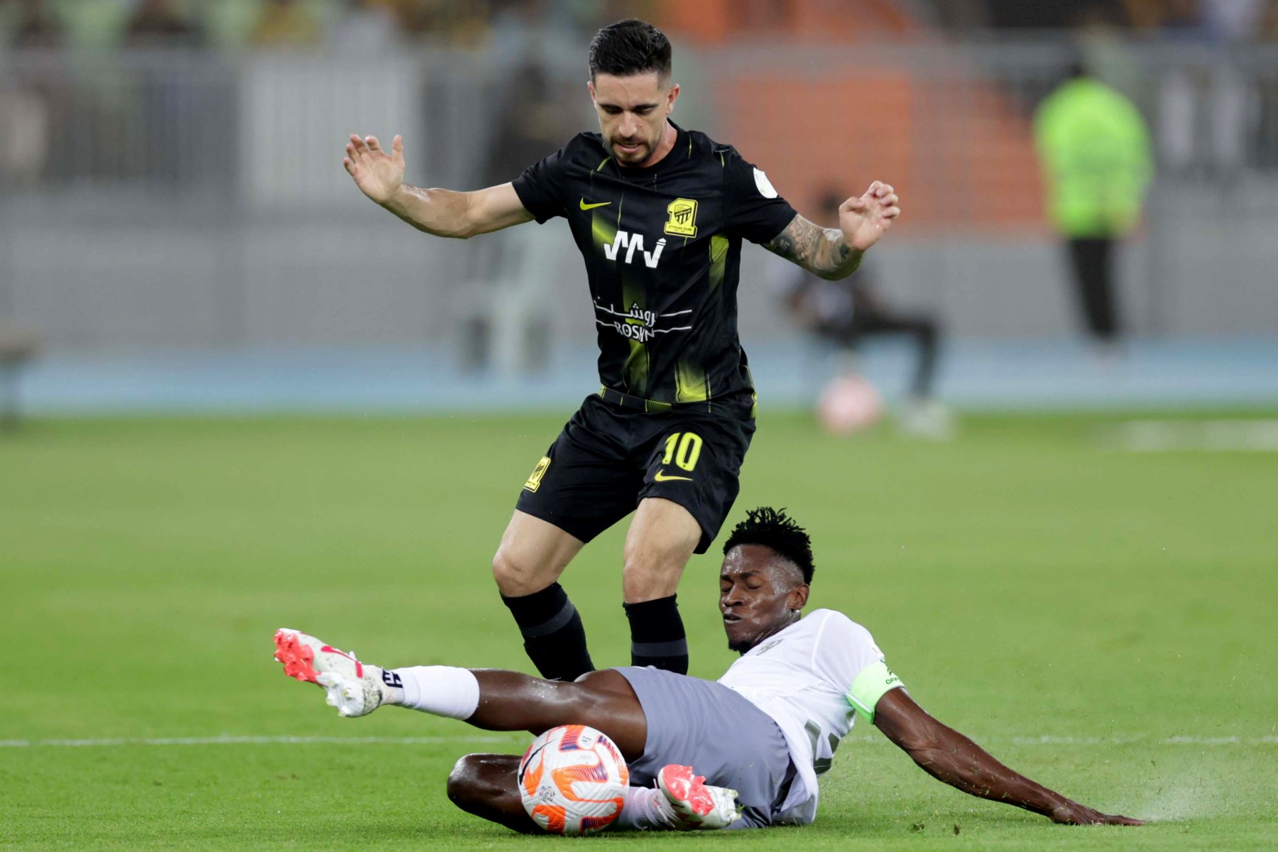Ittihad's Brazilian midfielder #10 Igor Coronado fights for the ball with Tai's Guinean midfielder Alfa Semedo #30 during the Saudi Pro League football match between Al-Ittihad and Al-Tai at the Prince Abdullah al-Faisal Stadium in Jeddah (AFP)