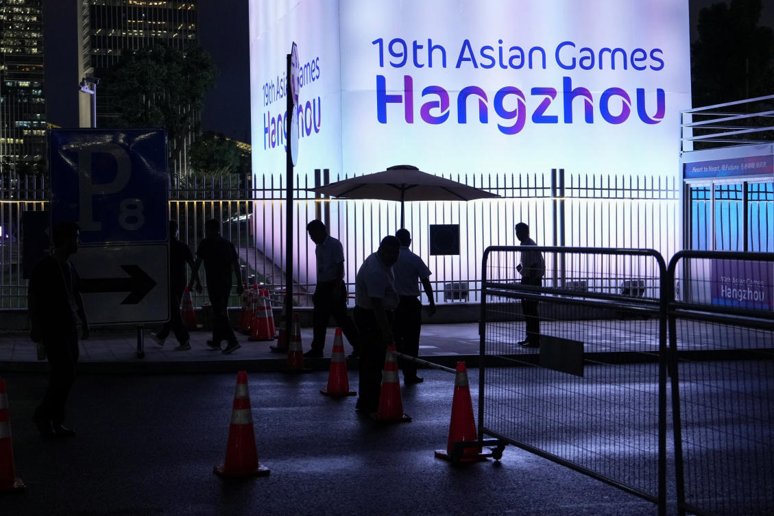 People stand near the Hangzhou Olympic Sports Center Aquatic Sports Arena ahead of the 19th Asian Games Hangzhou 2022 in Hangzhou, Zhejiang province, China on Sept. 20, 2023. (Reuters)