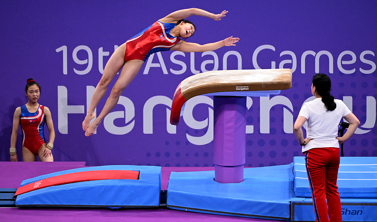 A gymnast from North Korea is watched by her coach during a training session ahead of the 2022 Asian Games in Hangzhou in China's eastern Zhejiang province on September 22, 2023. (AFP)