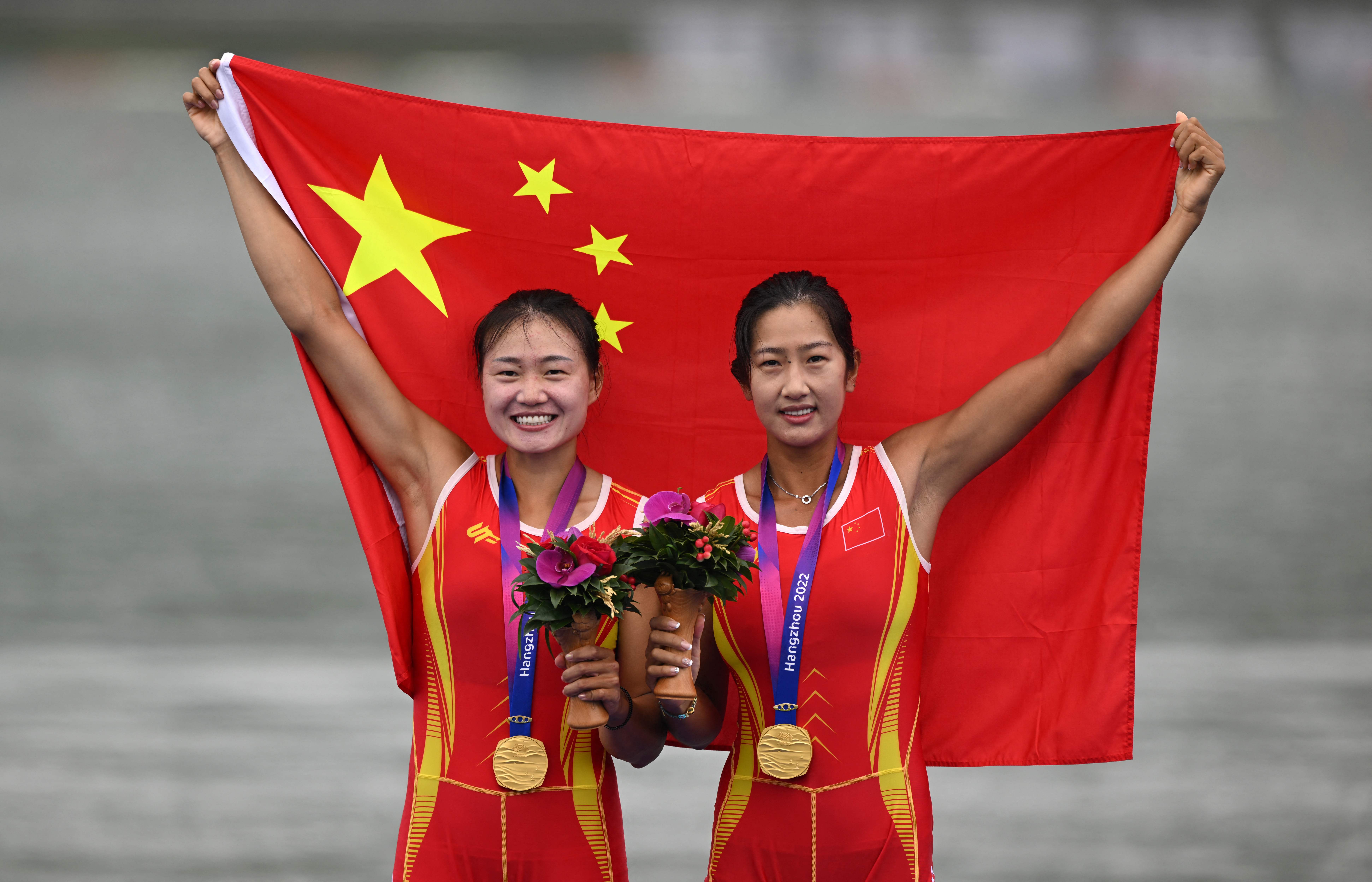 Gold medalists China's Lu Shiyu and Shen Shuangmei during a medal ceremony after the women's double sculls final event of rowing at the 2023 Asian Games in Hangzhou in China's eastern Zhejiang province on Sunday. (AFP)