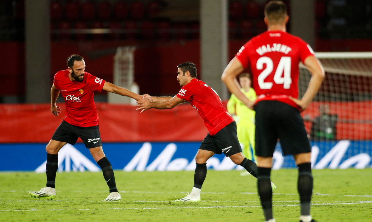 Real Mallorca's Spanish forward Abdon Prats (C) celebrates with Kosovar forward Vedat Muriqi after scoring their team's second goal during the Spanish Liga football match between RCD Mallorca and FC Barcelona on Tuesday. (AFP)