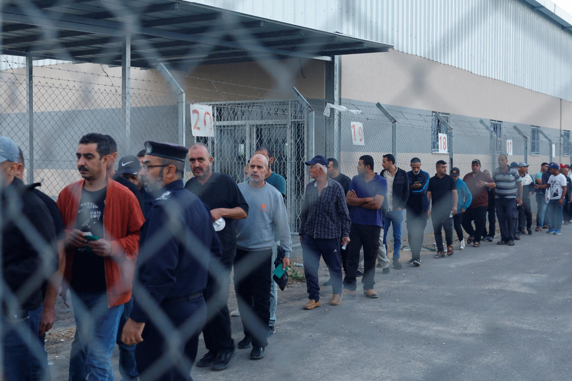 Palestinian workers enter the reopened Erez crossing to Israel, after Israeli ends a ban on workers from Gaza. (REUTERS)