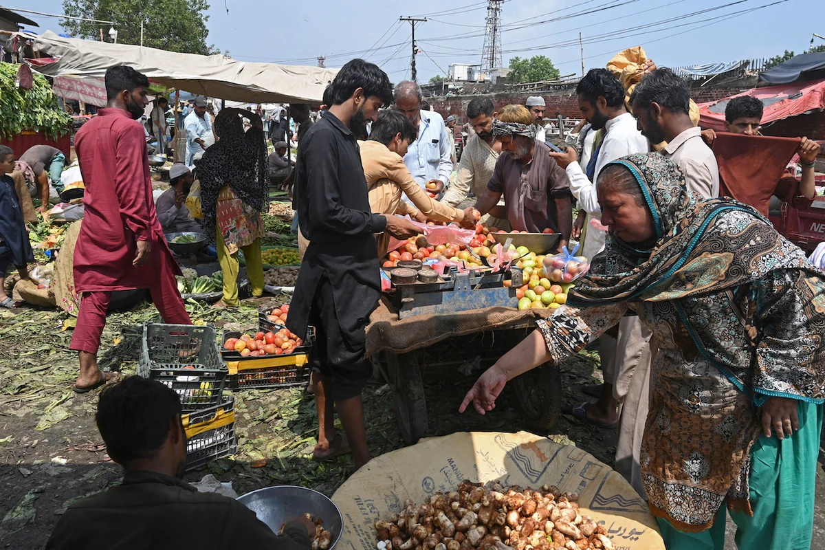 People buy fruits and vegetables at a local market in Lahore as monsoon floods in Pakistan send food prices skyrocketing. (AFP)