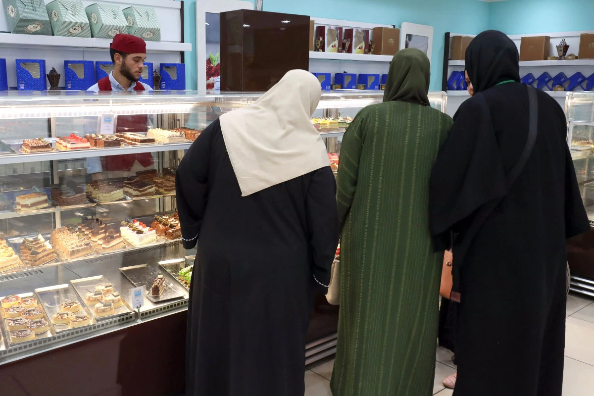 Libyans shop at a confectionary store in Tripoli on July 23, 2023. With new management at Gecol since last year, along with a relatively stable security situation, Libyans are receiving markedly improved electricity supply. (AFP))