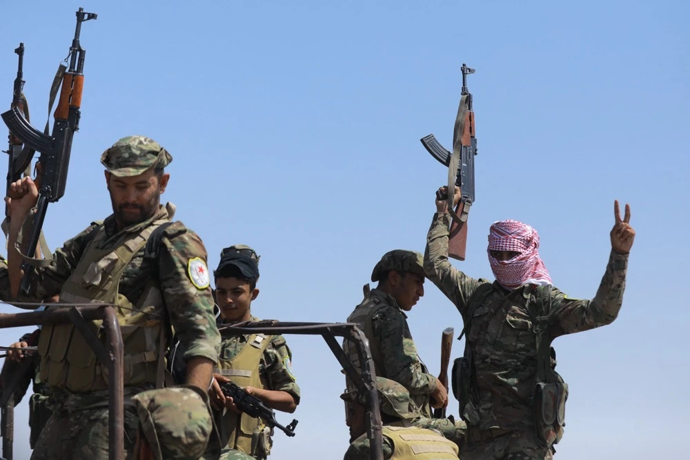 Fighters of the Syrian Democratic Forces (SDF) gesture as they move from Deir Ezzor to the Dhiban front line in eastern Syria on September 4, 2023. (AFP)
