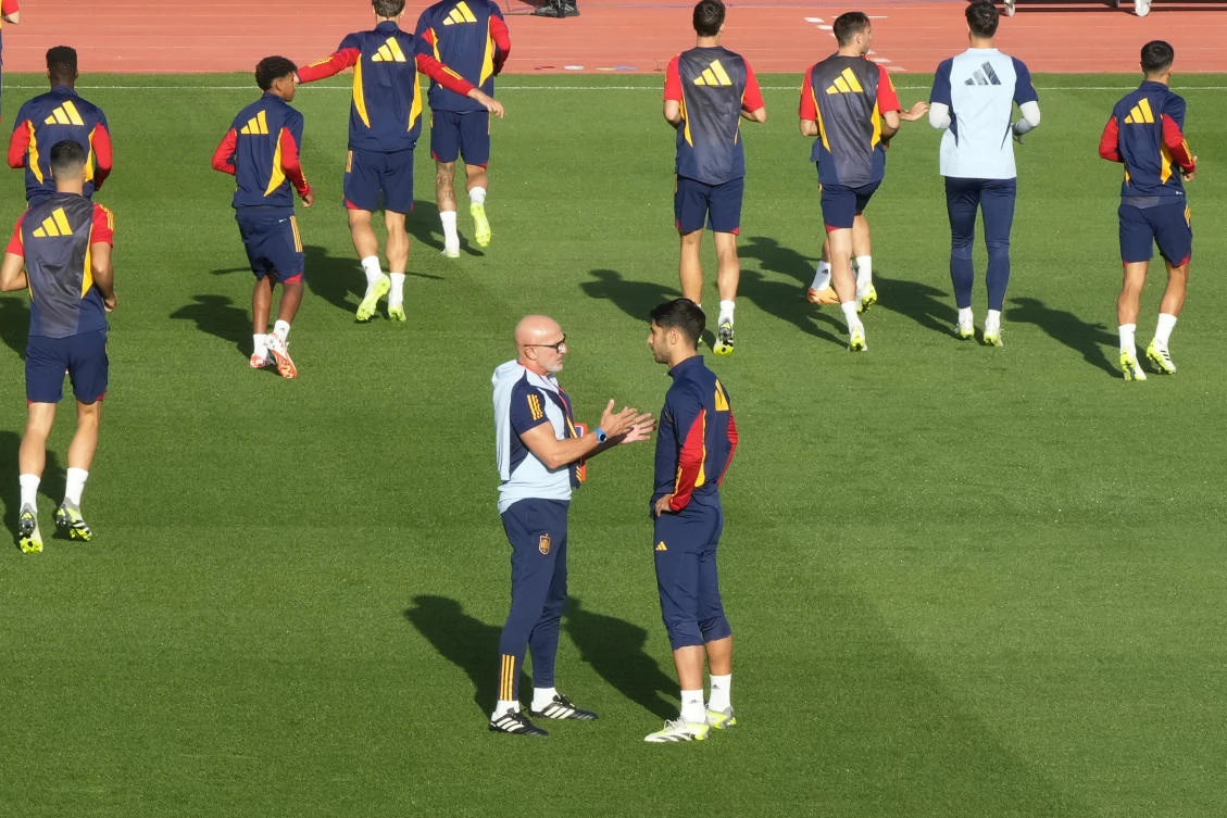 Spain's coach Luis de la Fuente speaks with Marco Asensio during a training session in Las Rozas just outside of Madrid, Spain, on Sept. 4, 2023. (AP)