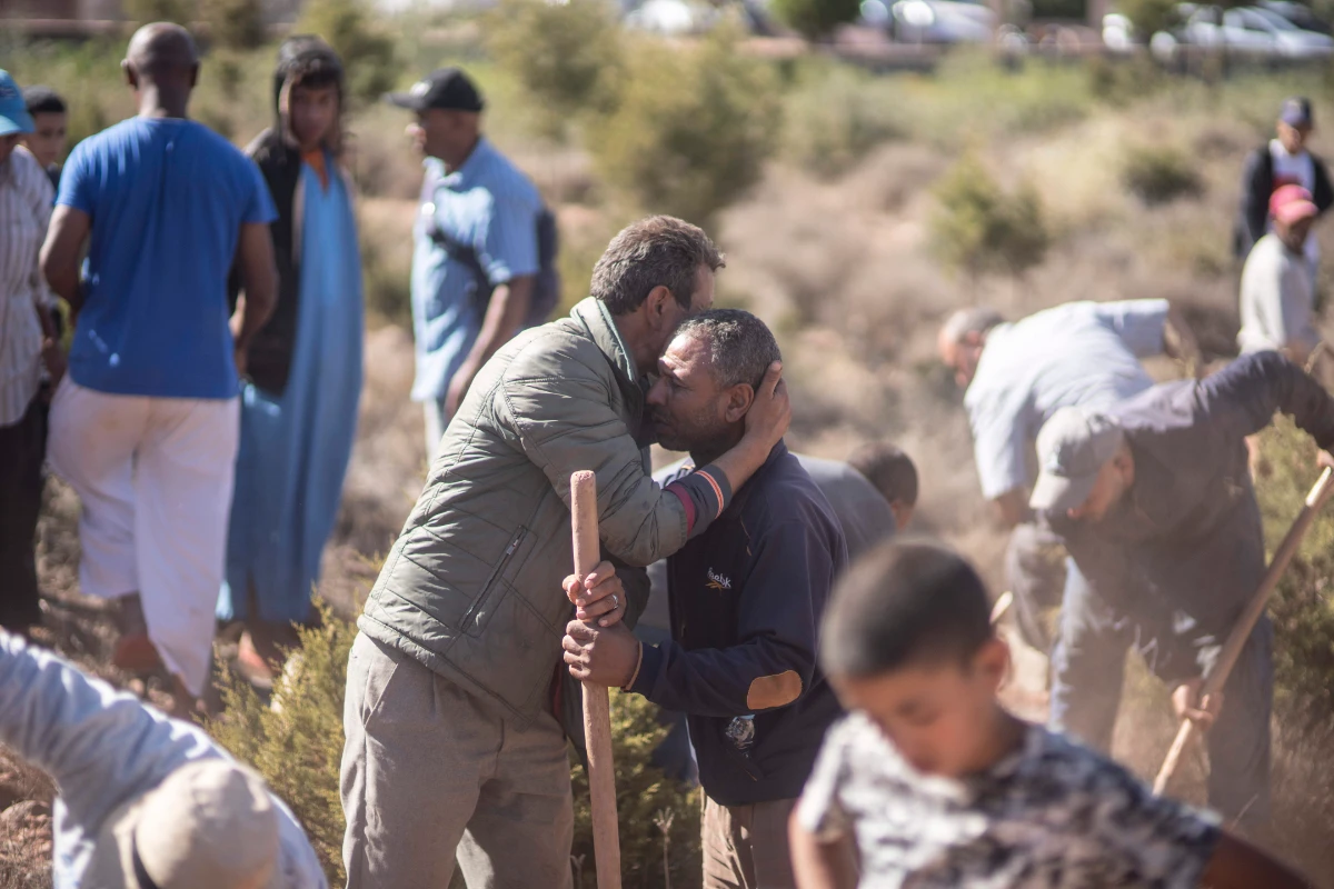 People comfort each other while digging graves for victims of the earthquake, in Ouargane village, near Marrakech, Morocco, Saturday, Sept. 9, 2023. (AP)
