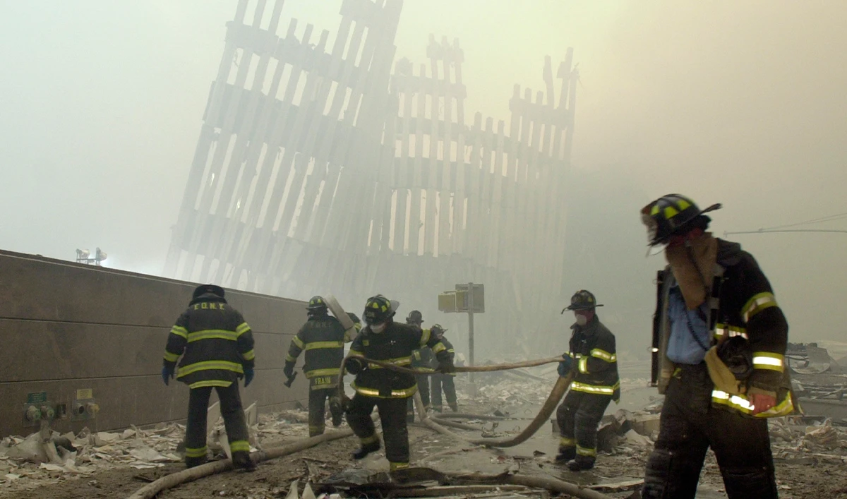 Firefighters work beneath the destroyed mullions, the vertical struts which once faced the soaring outer walls of the World Trade Center towers, after an attack in New York, on September 11, 2001. (Photo courtesy: AP/File)