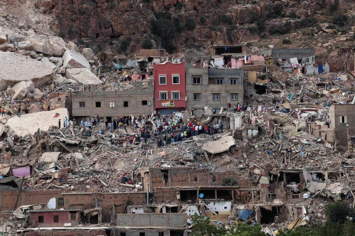 People stand on rubble in Imi N’Tala village, that was devastated by a deadly earthquake, Morocco on Sept.12, 2023. (Reuters)