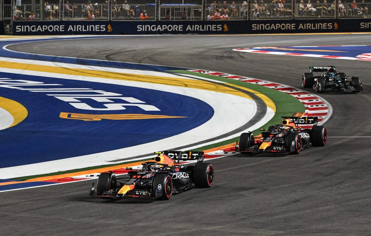 Red Bull Racing’s Mexican driver Sergio Perez and Dutch driver Max Verstappen and Mercedes’ British driver George Russell drive during the qualifying session of the Singapore F1 Grand Prix night race at the Marina Bay Street Circuit in Singapore on Sept. 16, 2023. (AFP)