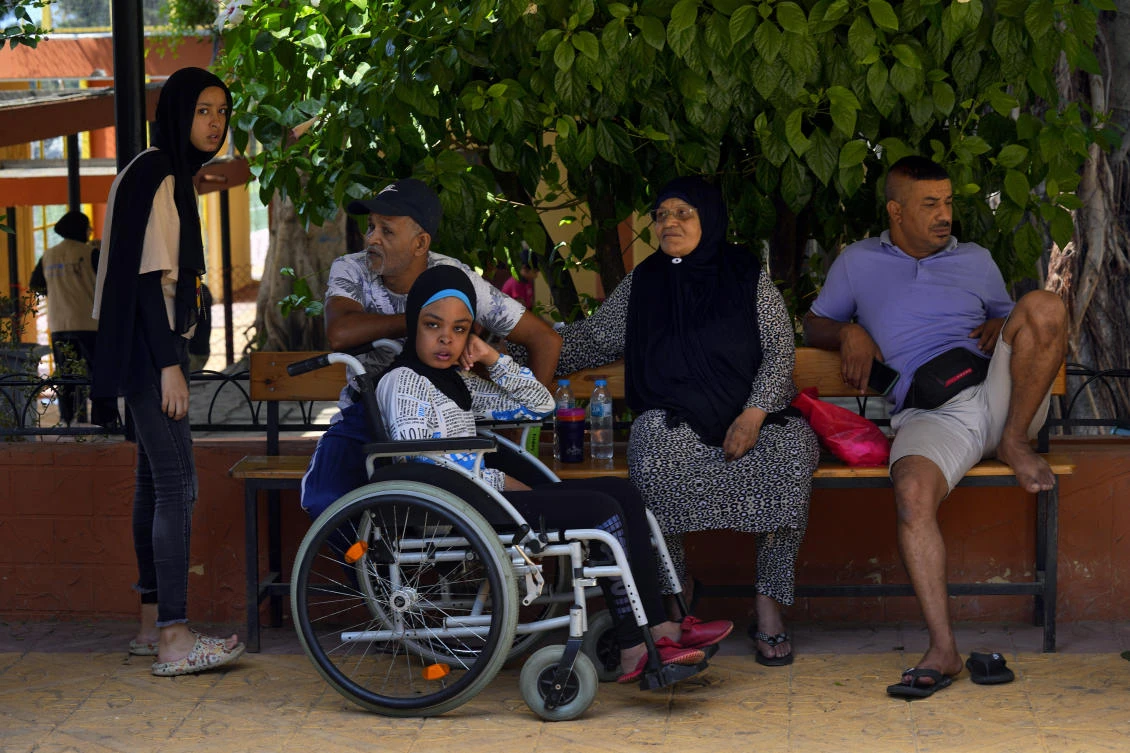 Palestinian refugee Munira Abu Aamsha, 63, second right, and other residents who fled their houses after clashes that erupted in Ein el-Hilweh refugee camp, sit at a UN-run training center in Sebline, south of Beirut on Sept. 20, 2023. (AP)