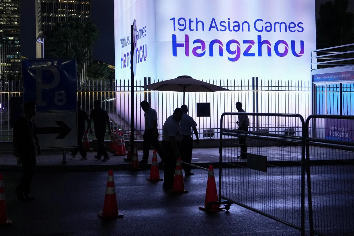 People stand near the Hangzhou Olympic Sports Center Aquatic Sports Arena ahead of the 19th Asian Games Hangzhou 2022 in Hangzhou, Zhejiang province, China on Sept. 20, 2023. (Reuters)