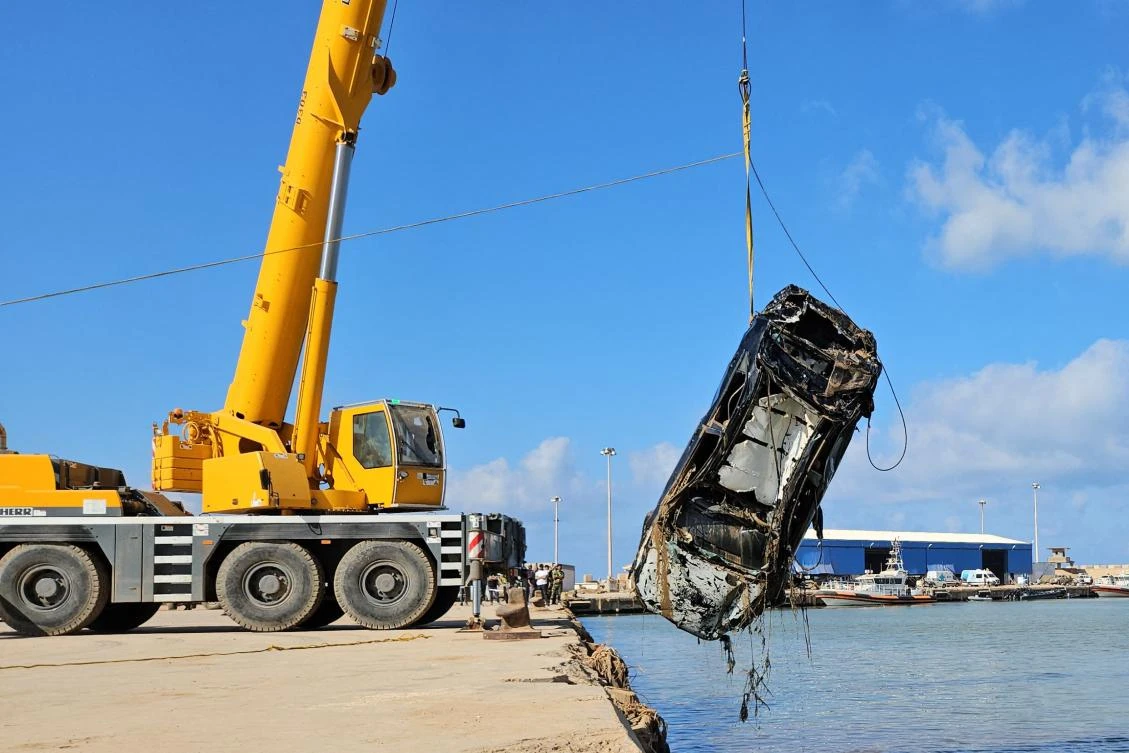 A car that was washed into the sea during the September 10 flood, is pulled out of the water after being found by Emirati divers, at the port of Libya's eastern city of Derna, on Sept. 20, 2023. (AFP)