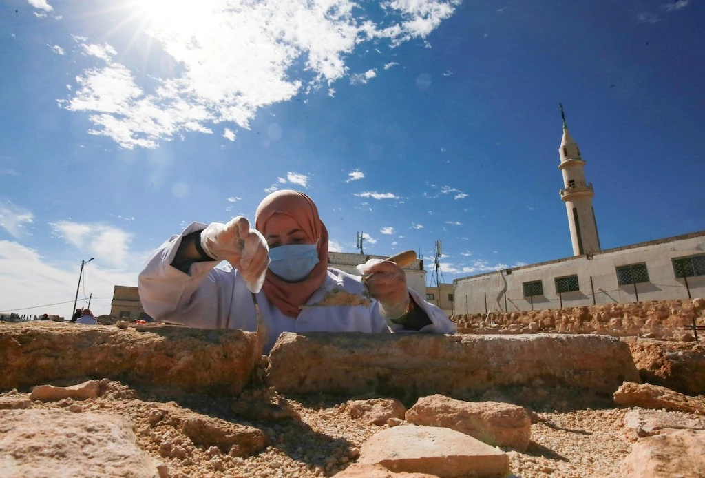 A worker employed by a pilot project run by the UN cultural agency UNESCO, restores a stone wall at an ancient church complex, in the small town of Rihab, some 70 kilometres north of the Jordanian capital Amman, on February 9, 2021. (File/AFP)
