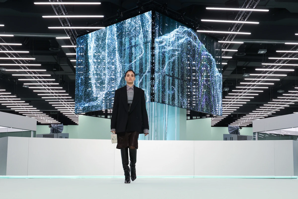 The athlete wore a grey shirt, an oversized black blazer, a knee-length skirt, leather boots and a white clutch. (Getty Images)