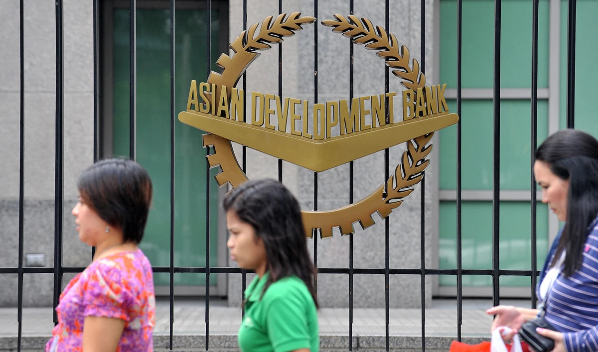 Pedestrians walk past a logo of the Asian Development Bank (ADB) displayed outside its headquarters in Manila, Philippines on September 2, 2010. (AFP/File)