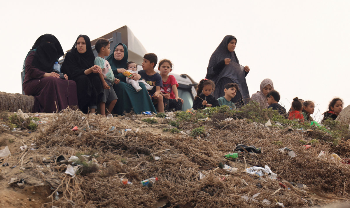 Palestinian women and children sit along the sea front in Deir El-Balah in the southern Gaza Strip on October 29, 2023. (AFP)