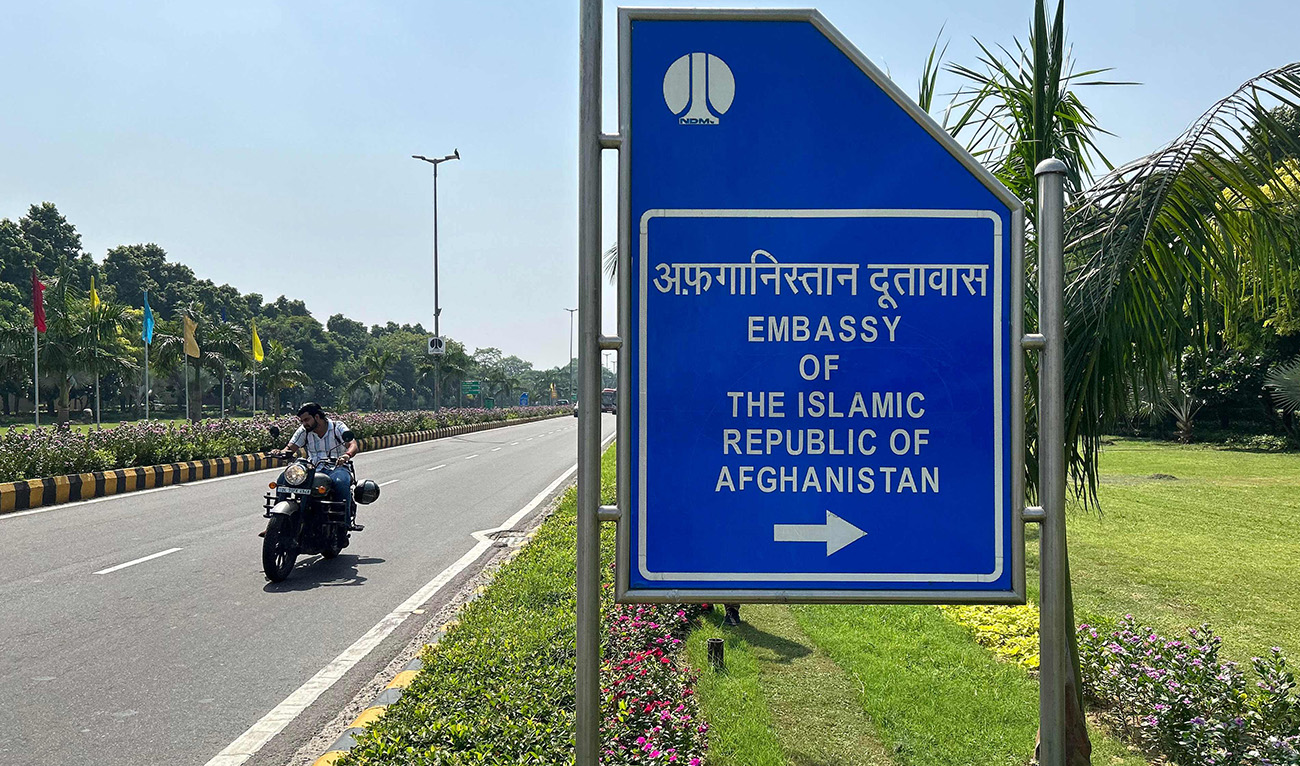 A motorist rides past a sign board for the embassy of the Islamic Republic of Afghanistan in New Delhi on September 29, 2023. (AFP)
