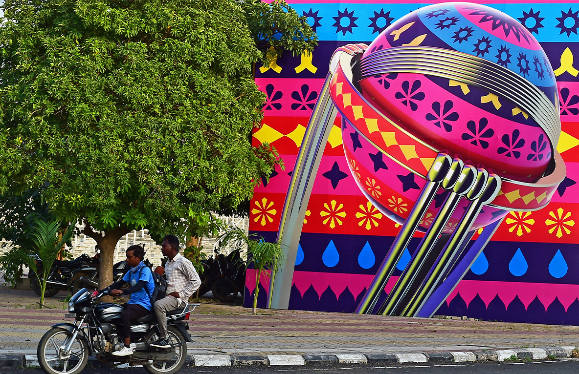 Motorcyclists ride past a billboard installed outside the Narendra Modi Stadium, ahead of the 2023 ICC men's cricket World Cup, in Ahmedabad, India, on September 30, 2023. (AFP/File)