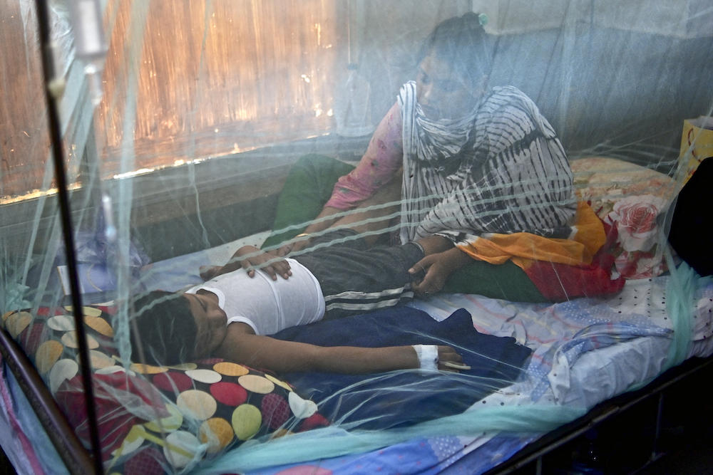 A woman comforts a child suffering from dengue fever at a government hospital in Dhaka on Oct 19, 2022. More than 1,000 people in Bangladesh have died of dengue fever since the start of the year, official figures show. (AFP)