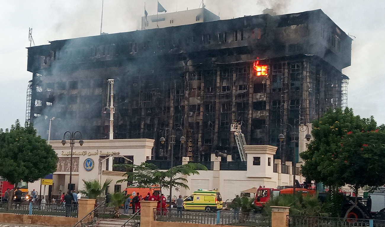 Firefighters try to extinguish a fire at a police headquarters in Ismailia, Egypt, on October 2, 2023. (AFP)