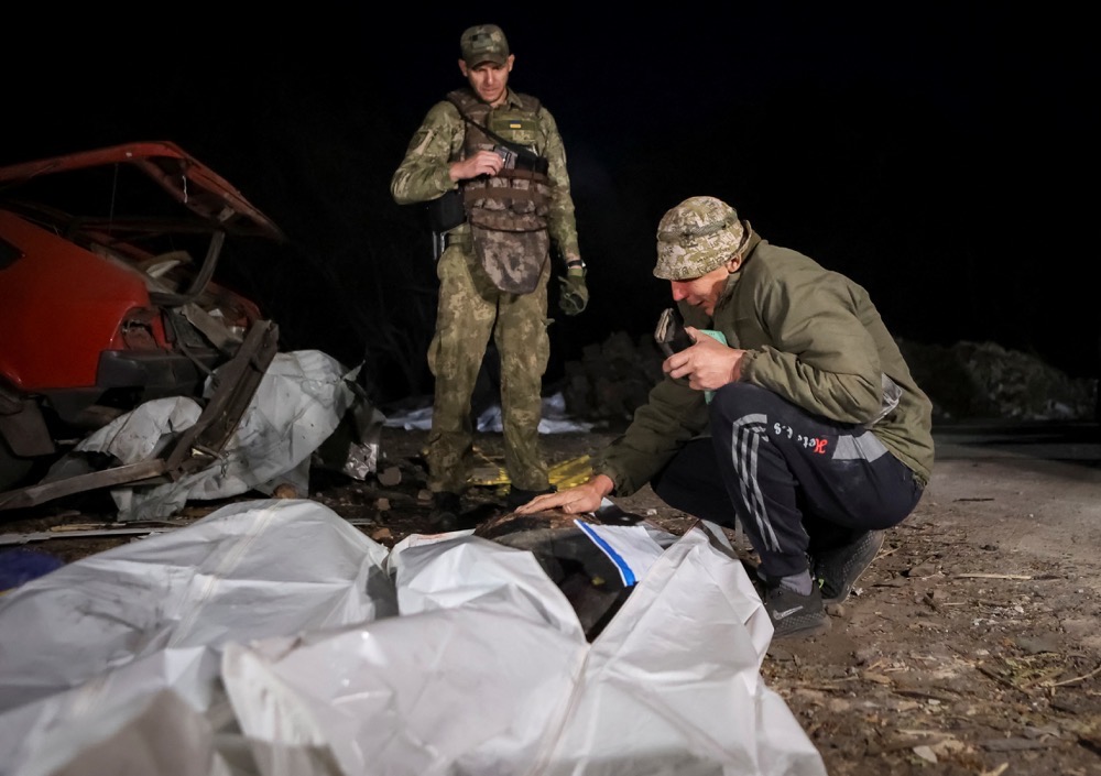 A man reacts near a body of a killed relative at a site of a Russian military strike, amid Russia's attack on Ukraine, in the village of Hroza, in Kharkiv region. (Reuters)