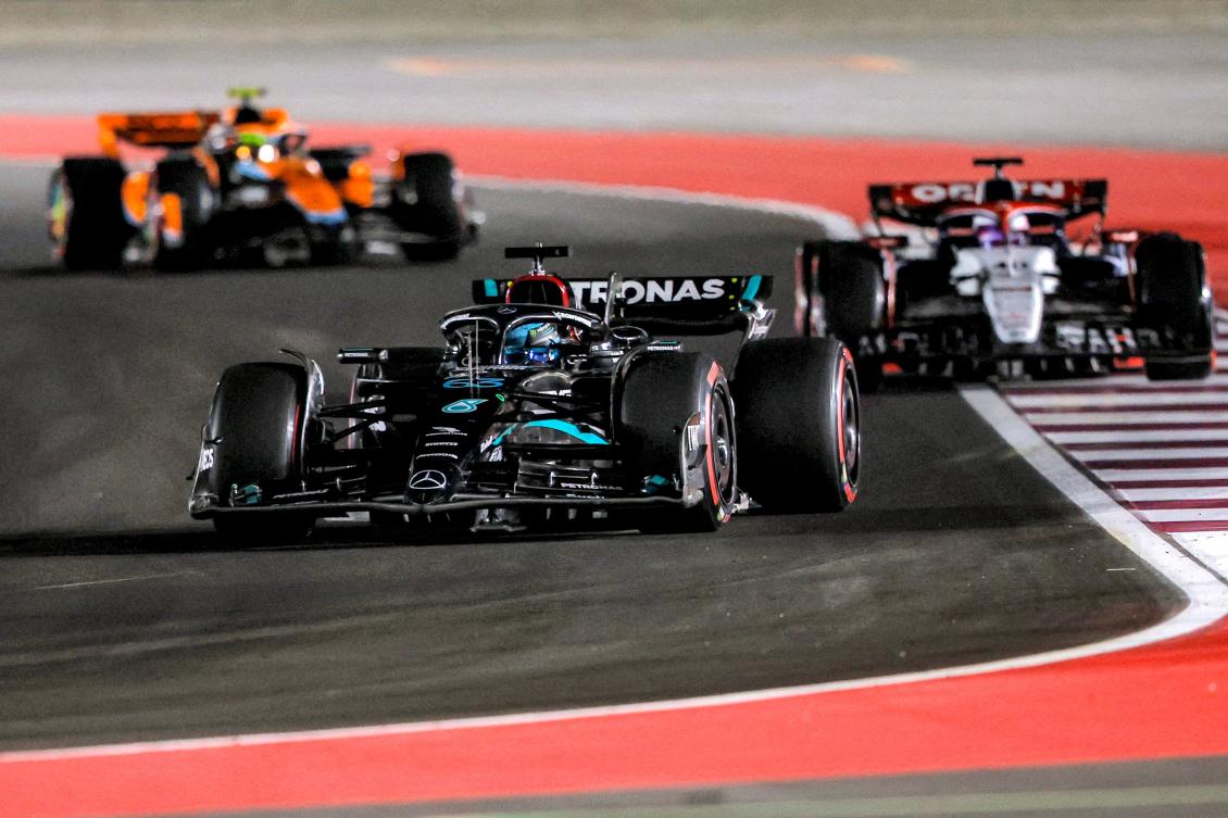Mercedes' British driver George Russell (front) drives ahead of Alpha Tauri's New Zealander driver Liam Lawson (R) and McLaren's British driver Lando Norris during the qualifying session ahead of the Qatari Formula One Grand Prix at the Lusail International Circuit on October 6, 2023. (Photo by KARIM JAAFAR / AFP)