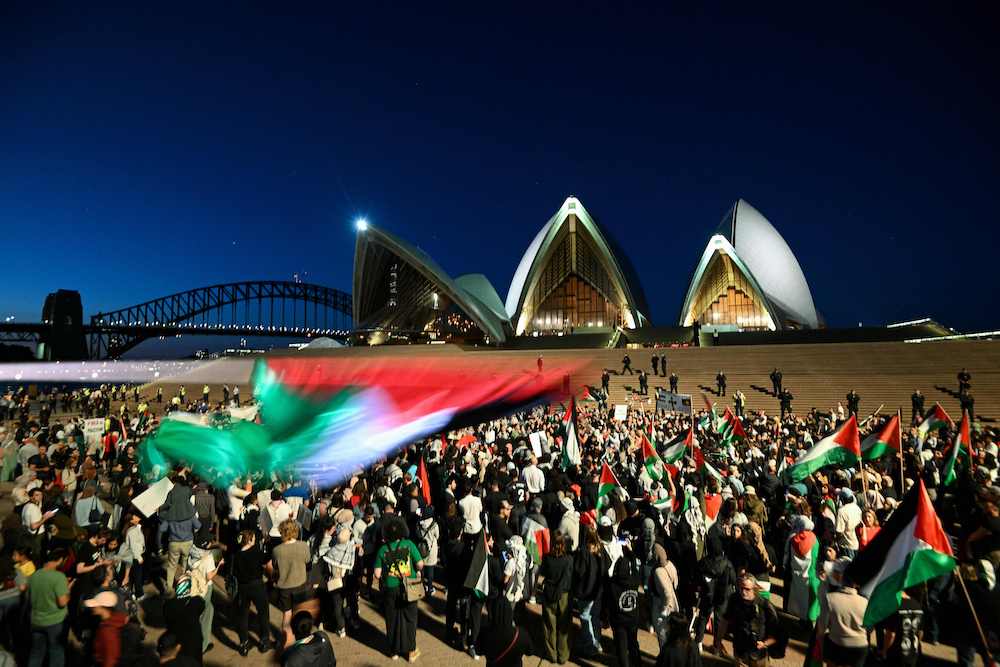 Protesters show their support for Palestinians during a rally in front of the Opera House in Sydney on Oct. 9, 2023. (AFP)
