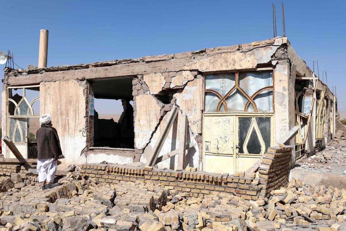 An Afghan man stands near a damaged house after the earthquakes in Sarbuland village, Zendeh Jan district of Herat province on October 8, 2023. (AFP)