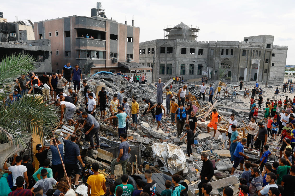 Palestinians walk among the rubble of a building destroyed in Israeli strikes, in the southern Gaza Strip October 9, 2023. (Reuters)