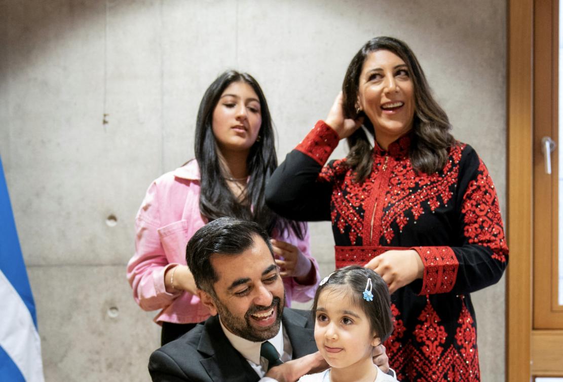 Humza Yousaf (C) is surrounded by his wife Nadia El-Nakla (rear R), his daughter Amal (2nd R), and his step-daughter Maya (rear L). (File/AFP)