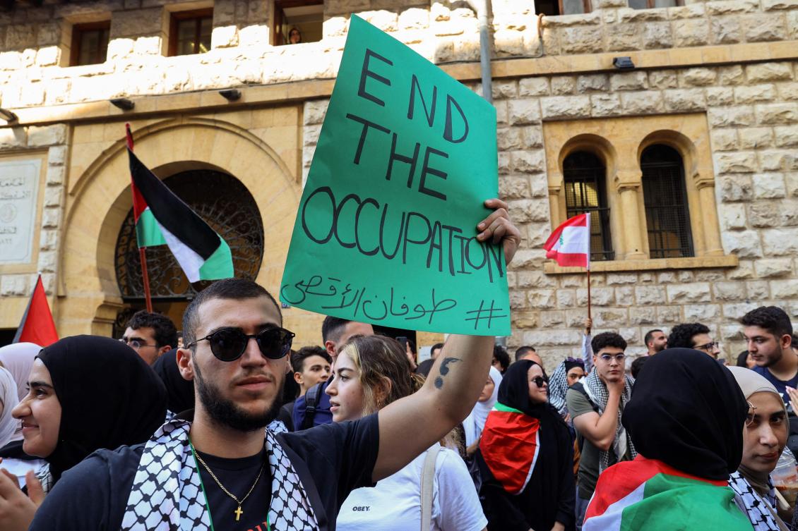 Students from the American University of Beirut (AUB) lift placards during a rally in support of Palestinians outside the main gate of the university in the Lebanese capital. (FILE/AFP)