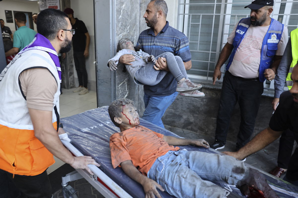 Medics transport wounded children into at al-Shifa hospital following Israeli strikes in Gaza City. (AFP)