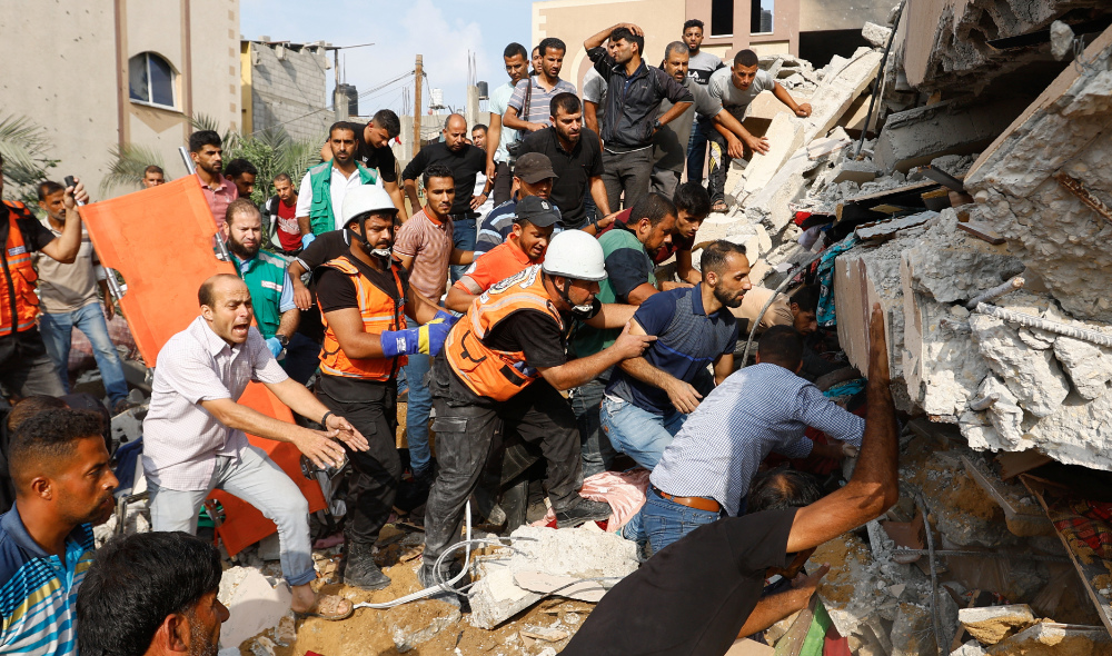 Palestinians search under the rubble of a house destroyed in Israeli strikes in Khan Younis, in the southern Gaza Strip. (Reuters)